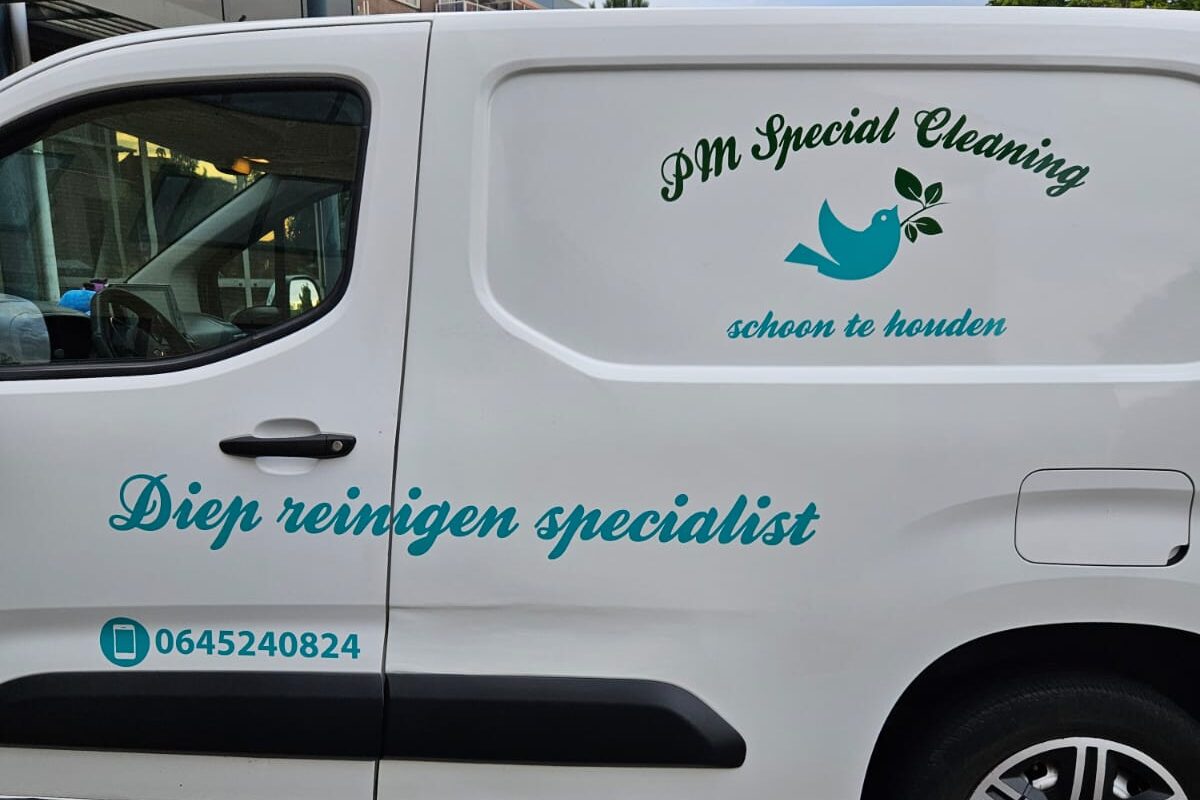Zijkant van de bedrijfsbus van PM Specialcleaning met logo en telefoonnummer